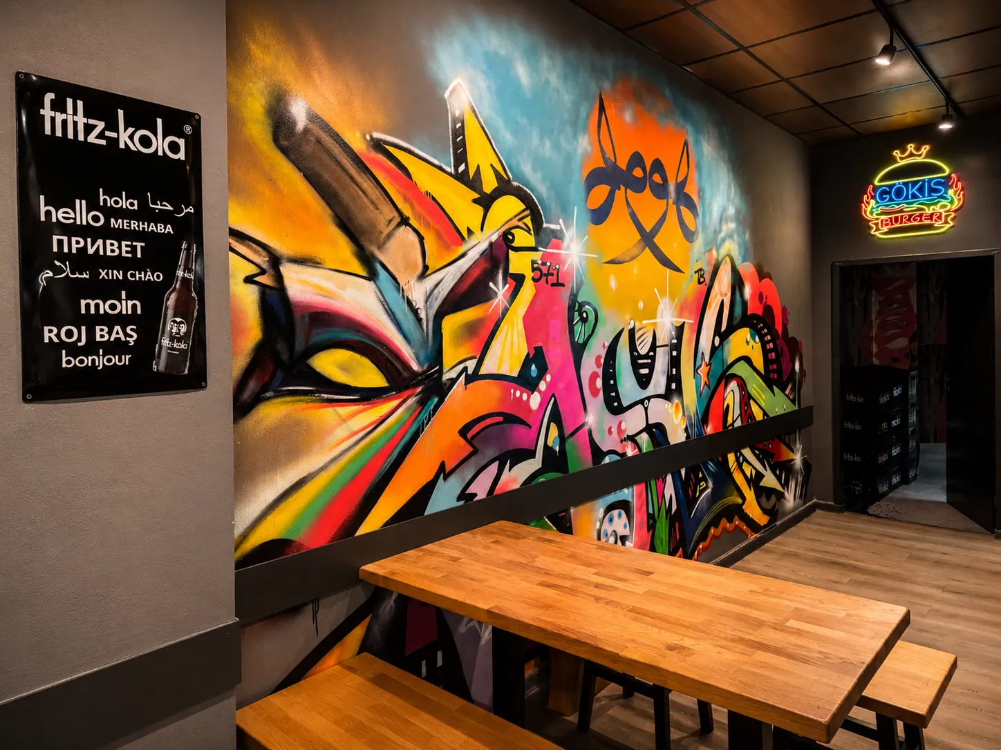 Graffiti-Mural mit Gökis-Burger-Neonschild im Laden